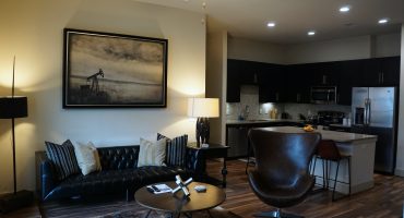 Living room with couch and coffee table, from the Texas design at Premier Patient Housing.