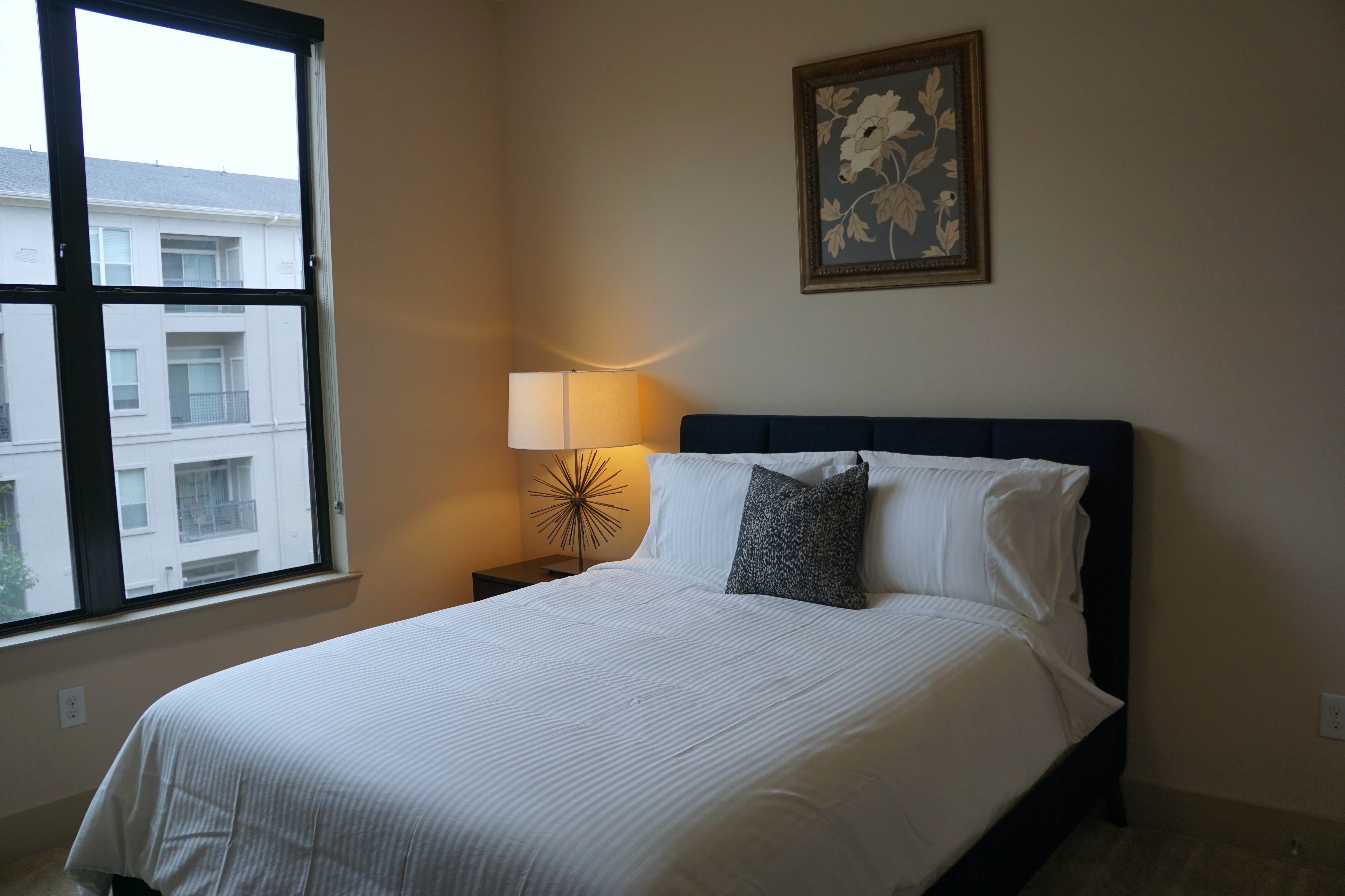 Low doorway view of bedroom with queen size bed from the Texas Design at Premier Patient Housing.