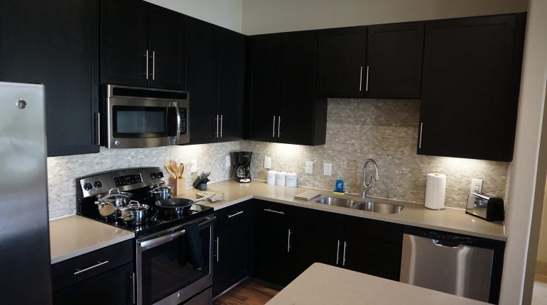 Full kitchen with fridge, oven, microwave and dining are on the island, from the Texas design at Premier Patient Housing.