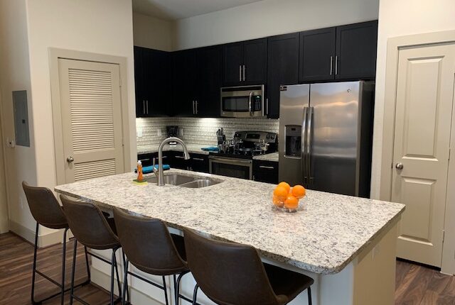 Full kitchen with fridge, oven, microwave and dining are on the island, from the Florida Design at Premier Patient Housing.