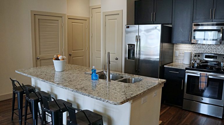 Full kitchen with fridge, oven, microwave and dining are on the island, from the California Design at Premier Patient Housing.