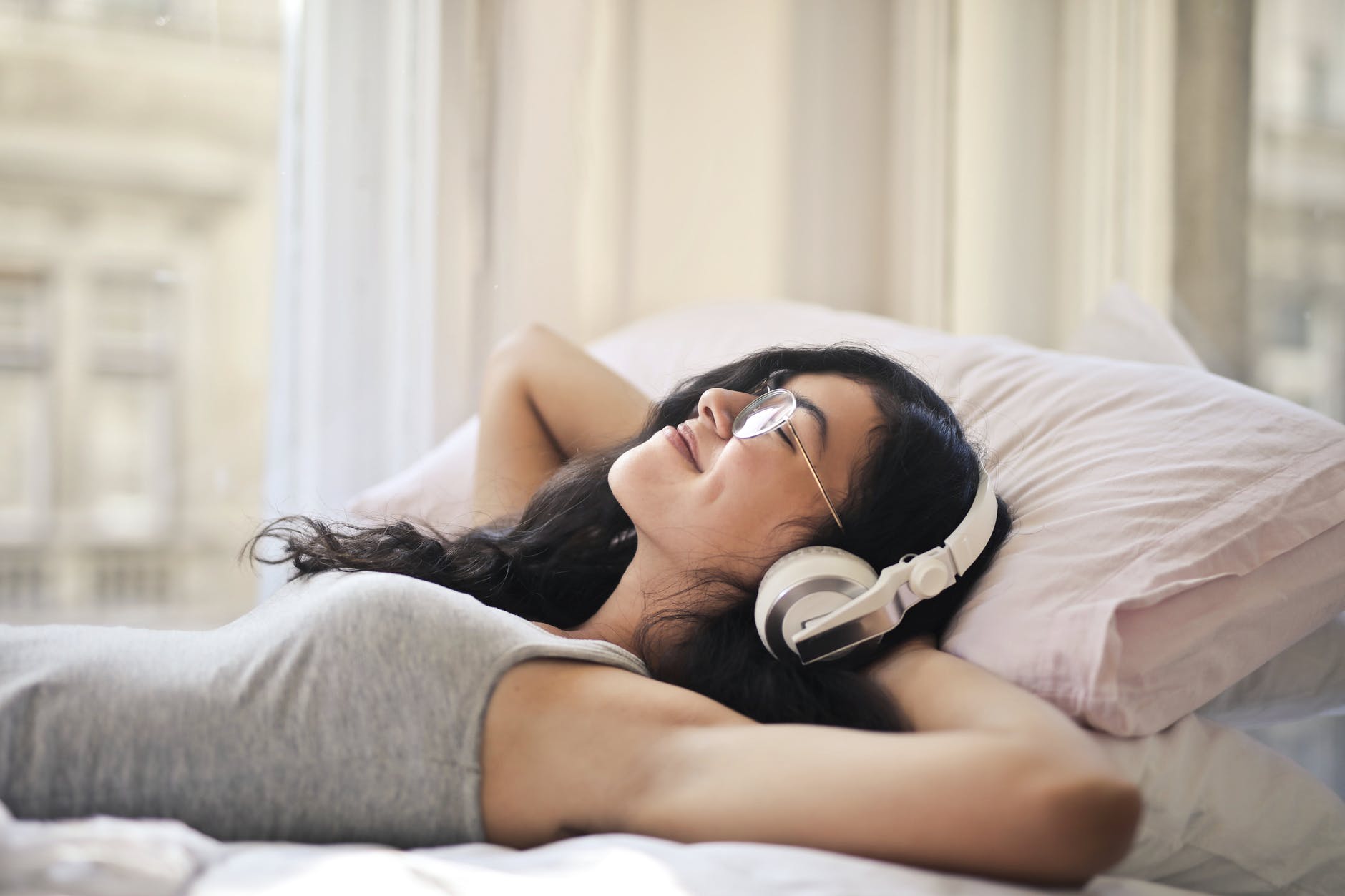 woman listening to soothing music on bed 