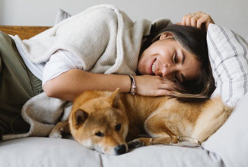 woman relaxing with dog on couch