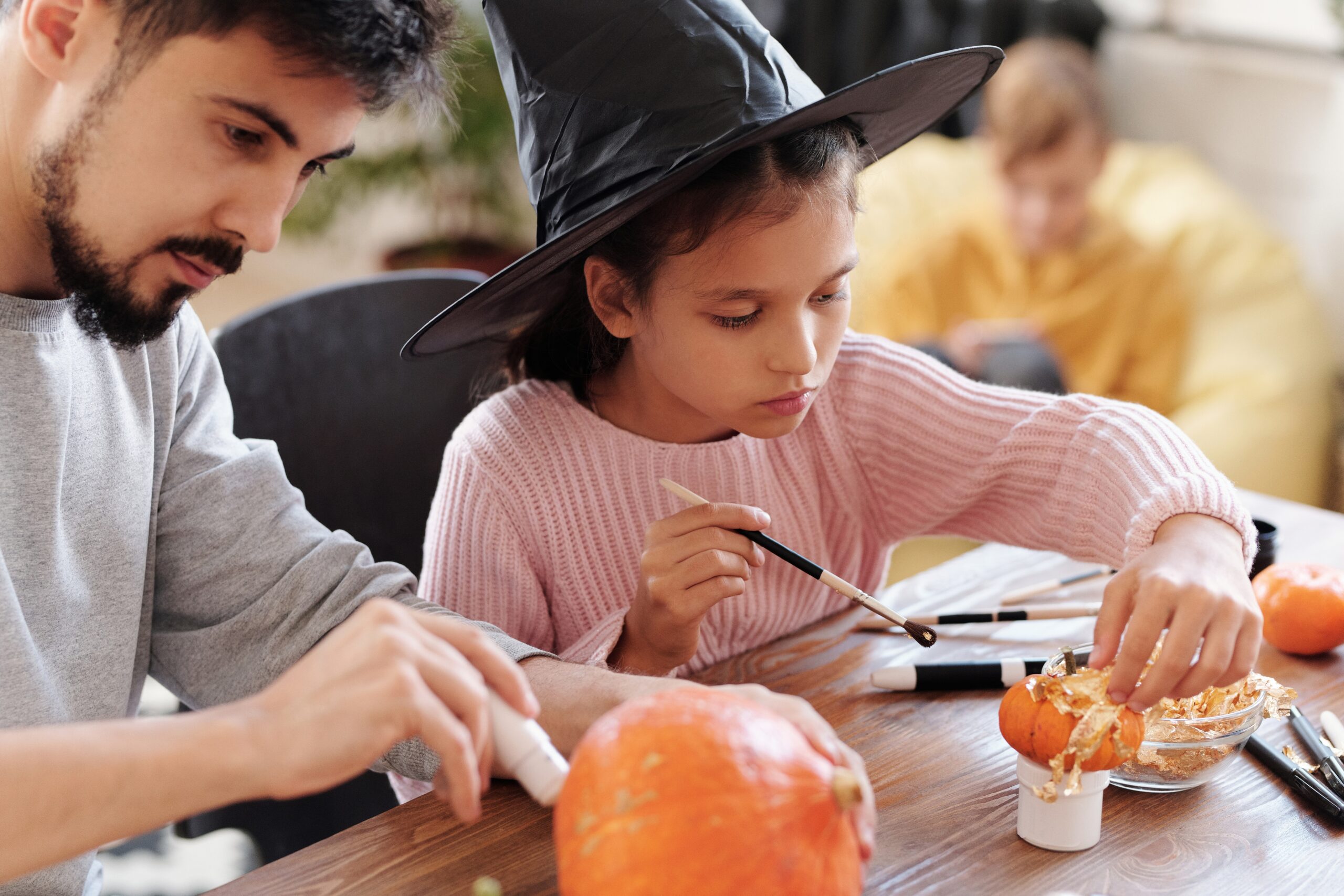 girl painting Halloween pumpkin 